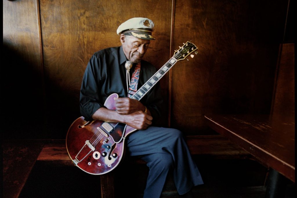 Chuck Berry holding his Gibson guitar wearing a sailors cap