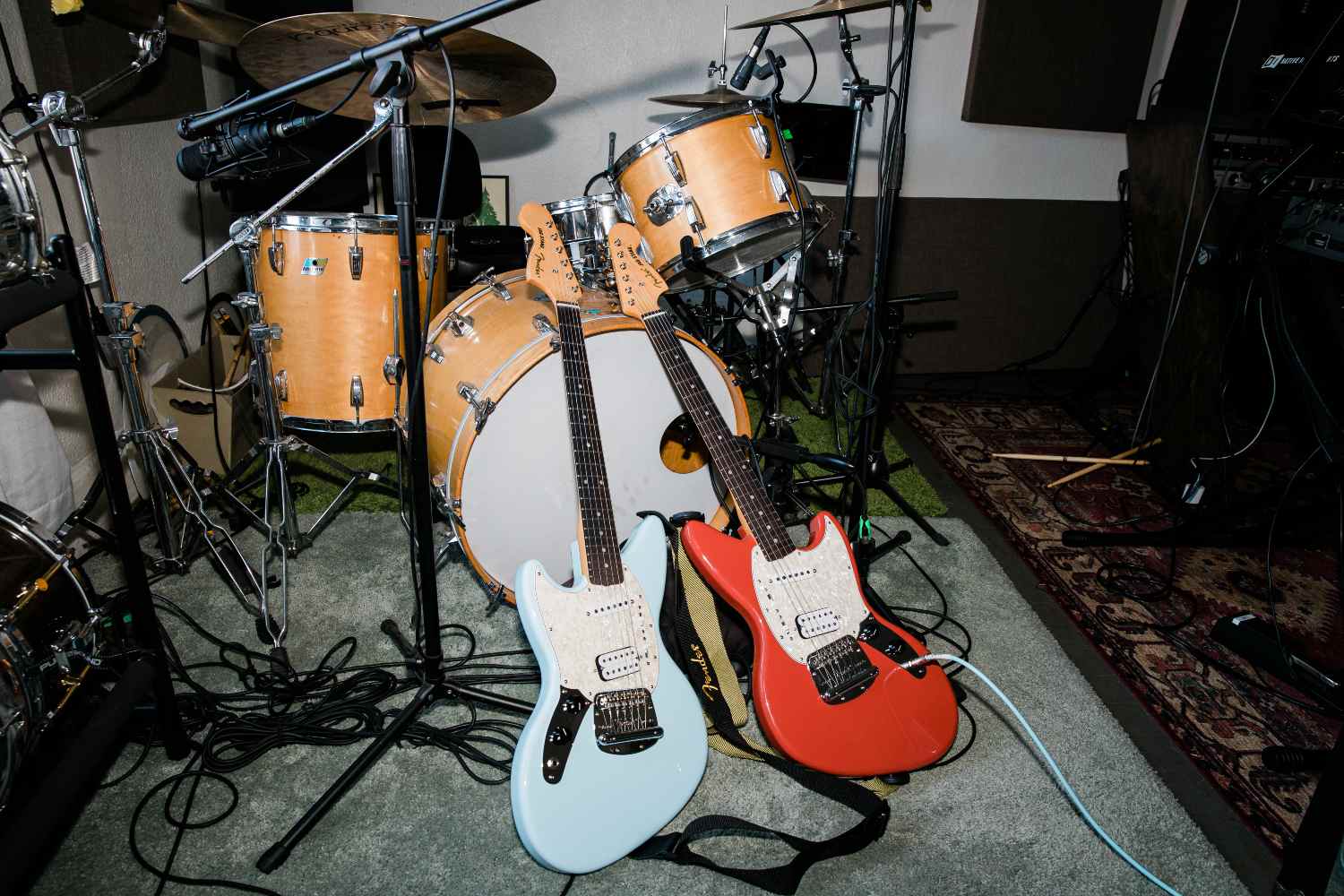 Fender Jag-Stang guitars resting on a drum kit