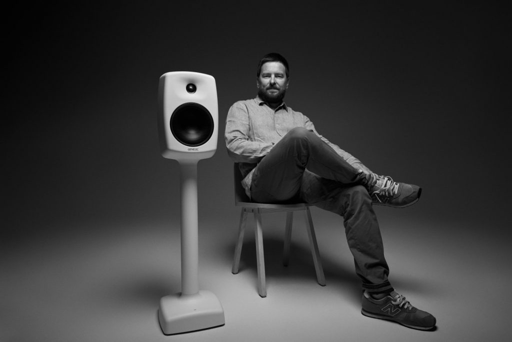 Harri Koskinen sitting next to Genelec 6040R loudspeaker